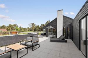 a patio with chairs and tables on a house at BV186-Blavand-Lyngsletten-41 in Blåvand