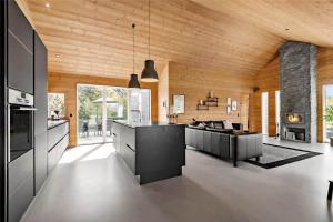 a kitchen with a stove and a living room at BV186-Blavand-Lyngsletten-41 in Blåvand
