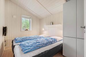 a bed in a small room with a refrigerator at BV235-Oksbol-Kaervej-2 in Oksbøl