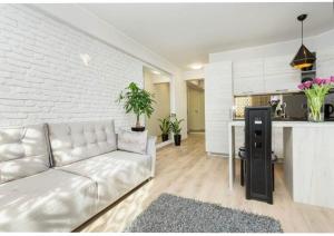 a living room with a white couch and a kitchen at Vega Residence in Tallinn
