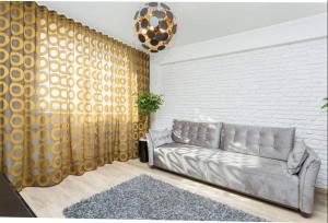 a living room with a couch and a brick wall at Vega Residence in Tallinn