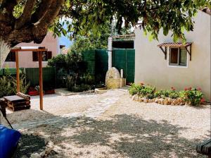 ein Hof mit einem Haus, einigen Pflanzen und einem Baum in der Unterkunft Villa Nikos in Sami