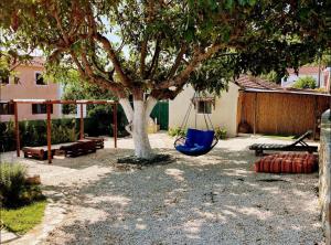 eine Schaukel unter einem Baum im Garten in der Unterkunft Villa Nikos in Sami + 3 Fotos