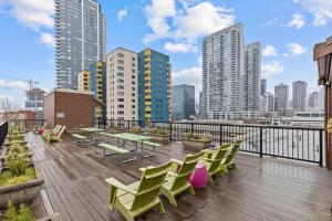 a balcony with green tables and chairs and a city skyline at Emerald City Penthouse in Seattle