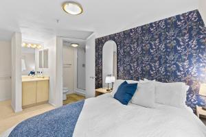 a bedroom with a large bed with a blue floral wallpaper at Emerald City Penthouse in Seattle