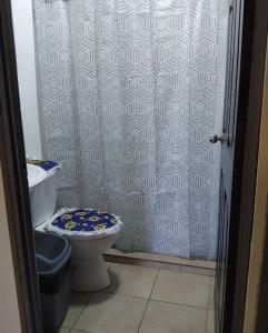 a bathroom with a shower curtain and a toilet at Casa en Santa Cruz a 40min de Tamarindo in Santa Cruz
