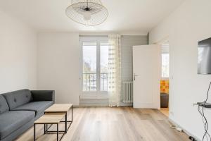 a living room with a couch and a table at appartement proche paris et Roissy in Persan