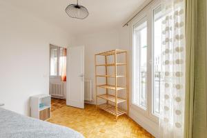 a bedroom with a book shelf next to a window at appartement proche paris et Roissy in Persan