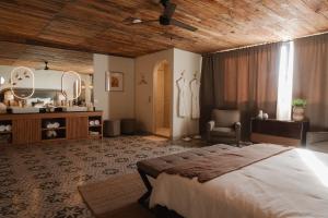 a bedroom with a large bed and a bathroom at Casa Frida in Valle de Guadalupe