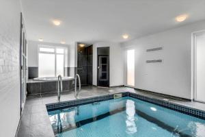 a bathroom with a swimming pool and a bath tub at BV284-Blavand-Blavand-Strand-4 in Blåvand