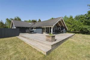 a house with a wooden deck in the yard at BV129-Blavand-Sonderballevej-47 in Blåvand