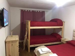 ein Schlafzimmer mit zwei Etagenbetten und einem Fernseher in der Unterkunft Laboulaye, Sarmiento 334 in Laboulaye