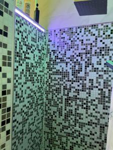 a bathroom with black and white tiles on the wall at Moderne Ferienwohnung in Mödling bei Wien in Mödling +9 photos