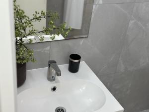 a white sink in a bathroom with a mirror at Modern City Apartment in Larnaka
