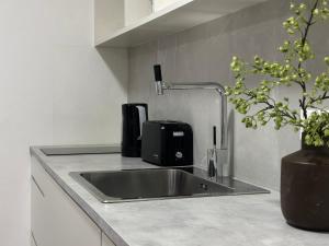 a kitchen counter with a sink and a appliance at Modern City Apartment in Larnaka +2 photos