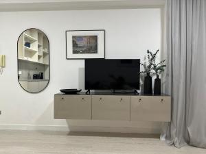 a living room with a television on a dresser at Modern City Apartment in Larnaka