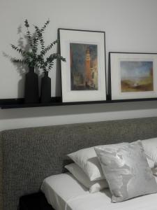 a shelf above a bed with three pictures on it at Modern City Apartment in Larnaka