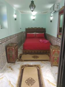 Un dormitorio con una cama roja con dos baúles. en RIAD El YacouT, en Marrakech