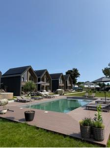 a swimming pool in a yard with houses at Wood House Trzęsacz in Trzęsacz