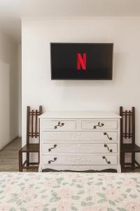 una camera da letto con cassettiera bianca e TV a parete di Espacio familiar paine 