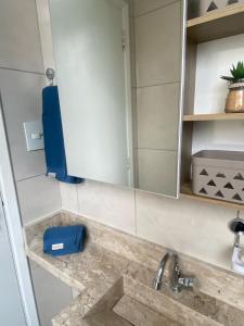 un comptoir de salle de bain avec un lavabo et un miroir dans l'établissement Studio Edifício Audax lindíssimo pé na areia - Melhor localização de São Vicente, à São Vicente