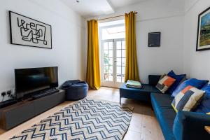 a living room with a blue couch and a television at Bristol Harbour, 2 bedroom townhouse with Parking in Bristol