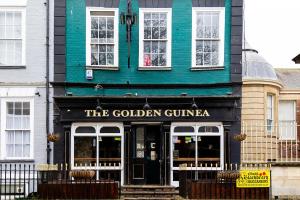 a green and black building with the golden guinea at Bristol Harbour, 2 bedroom townhouse with Parking in Bristol