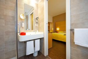 
a bathroom with a double sink and a large mirror at Ibis Styles Parma Toscanini in Parma

