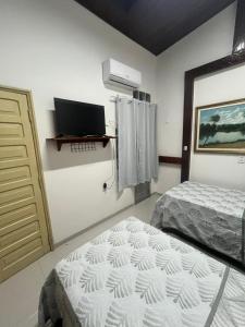 a bedroom with a bed and a computer on a wall at Casa da Ceiça in Belém