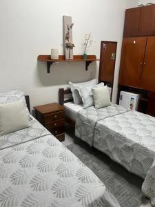 a bedroom with two beds and a dresser at Casa da Ceiça in Belém