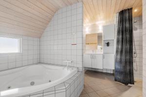 a large white bathroom with a tub and a kitchen at BV151-Blavand-Hedetoftvej-116 in Blåvand +19 photos