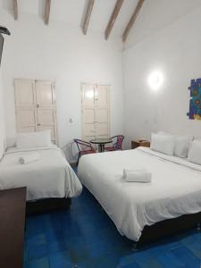a room with two beds and a table with chairs at Zana Hotel Boutique in Cartagena de Indias +84 photos