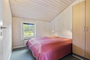 a bedroom with a bed and a window at BV157-Blavand-Gronnevaenget-11 in Blåvand