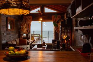 a living room with a bowl of fruit on a table at Cabañas Fischer SpA in Niebla