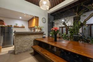a kitchen with a bar with a wooden counter at Sandat Living in Canggu