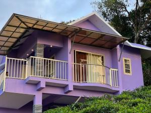 a purple house with a balcony at Calvin Cottages Vagamon in Vagamon
