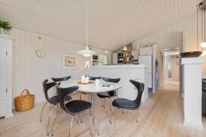 a kitchen and dining room with a table and chairs at BV325-Blavand-Tvaervaenget-8 in Blåvand