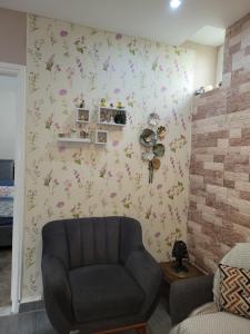 a living room with a chair and flowers on the wall at sweet home in Alger