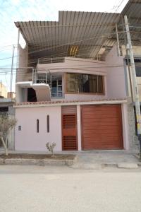 ein weißes Haus mit zwei Garagentüren darauf in der Unterkunft Casa de La Reina in Chiclayo