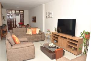 ein Wohnzimmer mit Couch und Flachbildfernseher in der Unterkunft Casa de La Reina in Chiclayo
