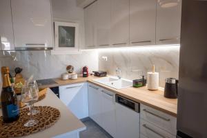 a white kitchen with white cabinets and a sink at The Circle Point Apartment in Larisa +16 photos
