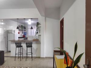 una cucina con un bancone e sgabelli in una stanza di Cantinho do mumu a Ouro Preto Altre 32 foto