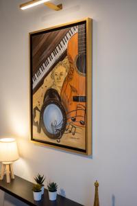 a painting of a guitar on a wall at The Circle Point Apartment in Larisa