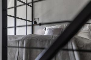 a bed with white sheets and pillows next to a window at Sea Loft 49 in Gdynia