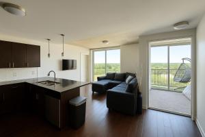 Una cocina y una sala de estar con un sofá y una mesa. en 2 bedroom downtown highrise, en Raleigh
