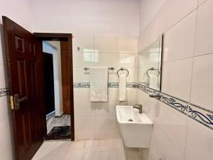a white bathroom with a sink and a mirror at Ziel Hotels & Guest House Islamabad Near US Embassy & VFS Global in Mohra Nūr