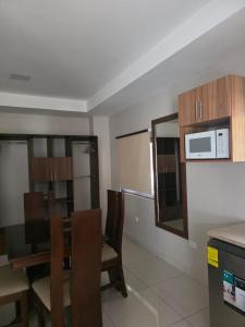 Una cocina con mesa y sillas y un microondas. en Hostal Boutique Isabel, en Managua