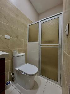 Un baño con inodoro y ducha de cristal. en Hostal Boutique Isabel, en Managua