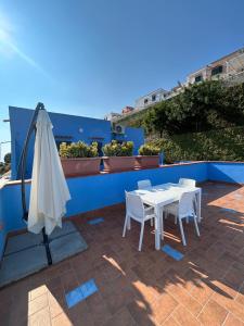 a white table and chairs and an umbrella on a roof at STILL HOUSE in San Nicola Arcella +56 photos