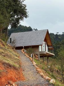 a house on top of a hill with a gravel road at Chalé Garden da Mantiqueira in Monte Verde